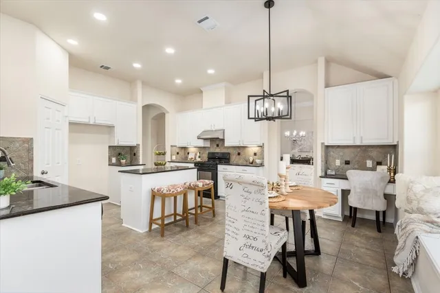 a large kitchen with a table and chairs