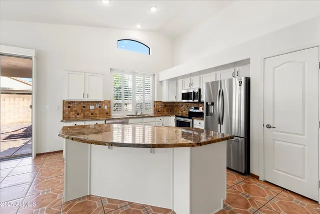a kitchen with stainless steel appliances kitchen island granite countertop a sink and cabinets