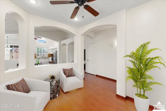 a view of a big room with wooden floor a ceiling fan and windows