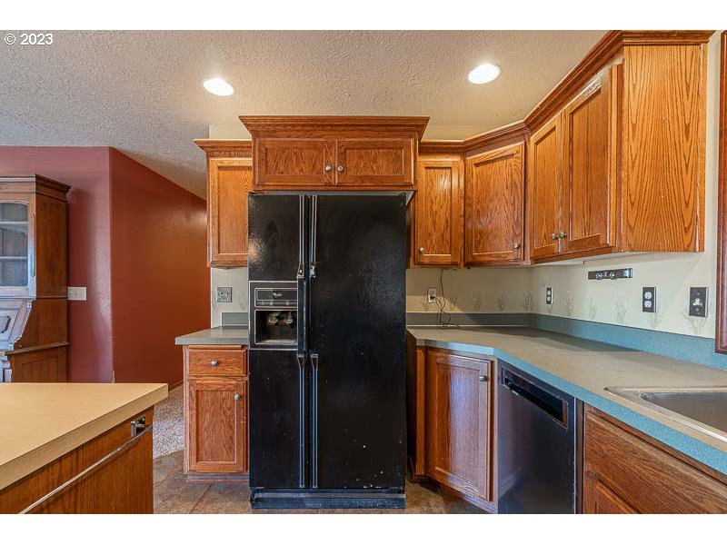 6295 Kings Ridge Road Dallas, OR 97338 - Photo 8 of 44 a kitchen with stainless steel appliances granite countertop a refrigerator and a sink