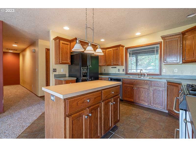 6295 Kings Ridge Road Dallas, OR 97338 - Photo 9 of 44 a kitchen with a sink a stove a refrigerator and a window