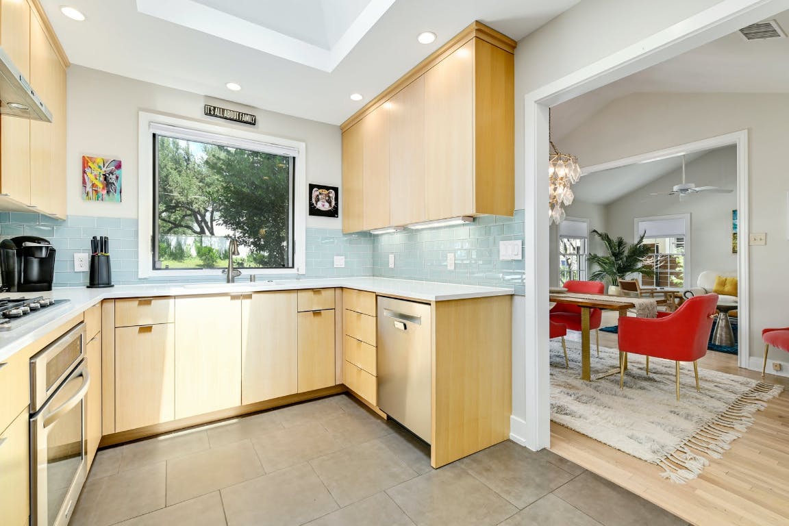 3321 Windsor Road Austin, TX 78703 - Photo 26 of 28 a large white kitchen with granite countertop a sink and white cabinets