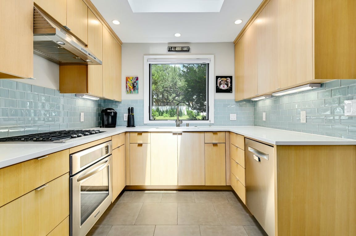 3321 Windsor Road Austin, TX 78703 - Photo 6 of 28 a kitchen with stainless steel appliances granite countertop a sink window and cabinets