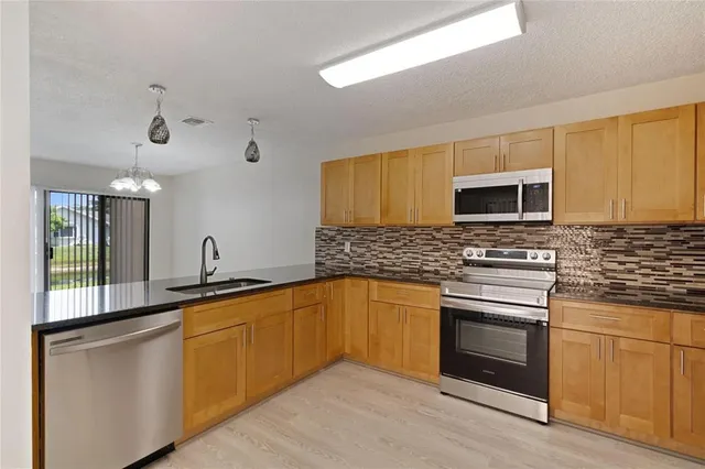 a kitchen with stainless steel appliances granite countertop a sink and stove top oven
