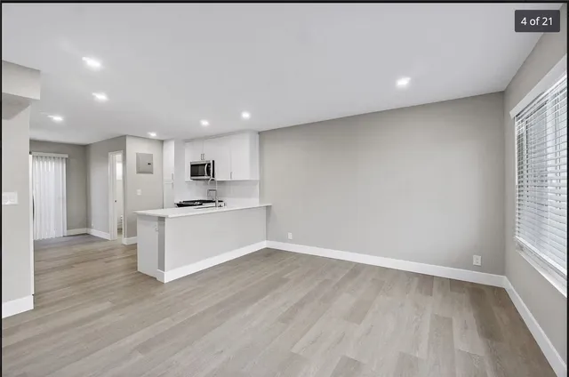a view of kitchen with wooden floor and electronic appliances