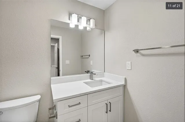 a bathroom with a sink a toilet and a mirror