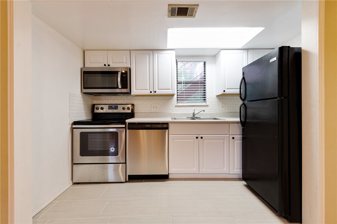 706 West 22nd Street, Unit 202 Austin, TX 78705 - Photo 14 of 24 a kitchen with stainless steel appliances a refrigerator stove and microwave