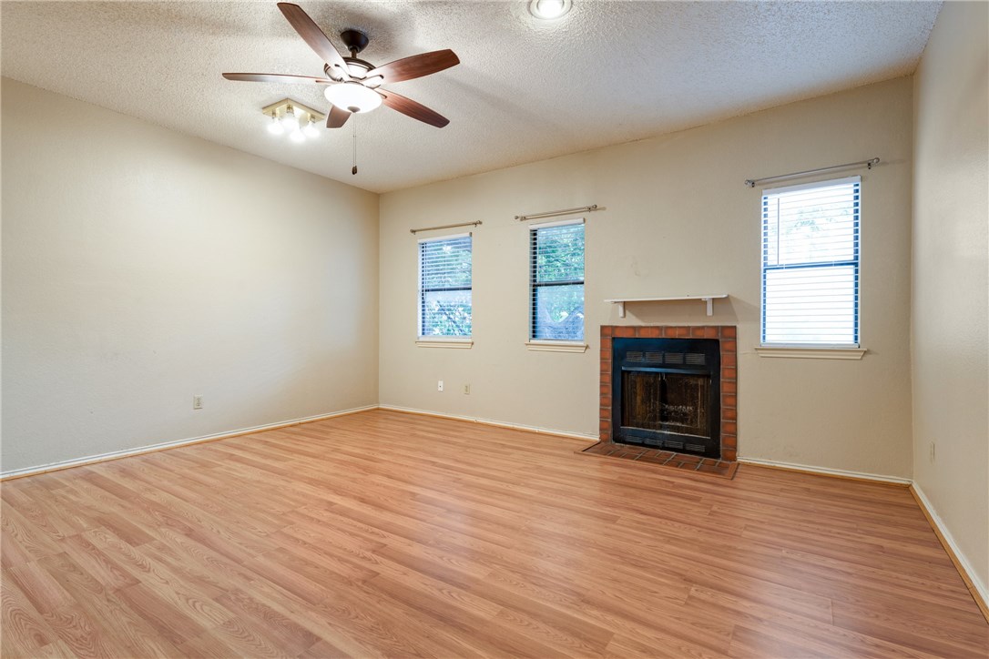 706 West 22nd Street, Unit 202 Austin, TX 78705 - Photo 3 of 24 an empty room with windows fireplace and a wooden floor