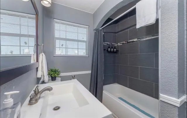 a bathroom with a tub sink and mirror