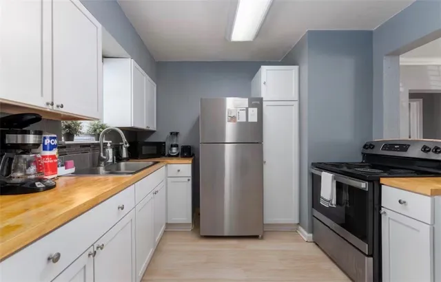 a kitchen with stainless steel appliances granite countertop a refrigerator a stove and a sink