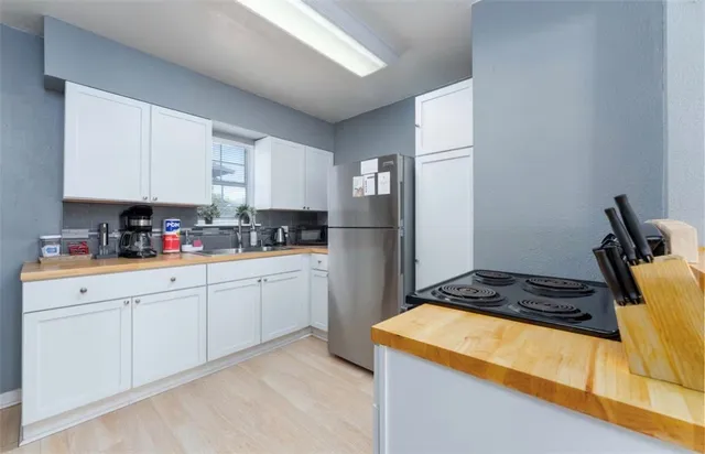 a kitchen with a refrigerator a stove a sink and cabinets