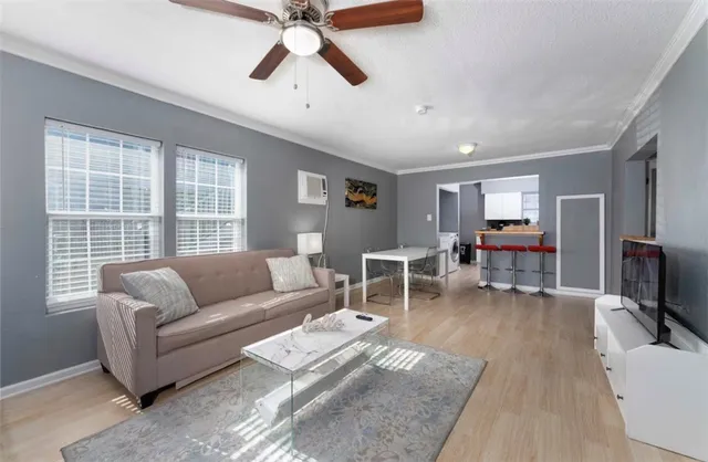 a living room with furniture a ceiling fan a fireplace and a window