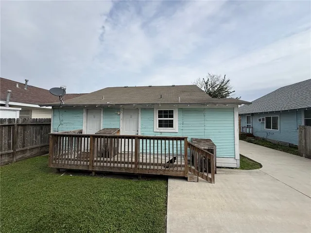a view of a house with a wooden deck and a yard