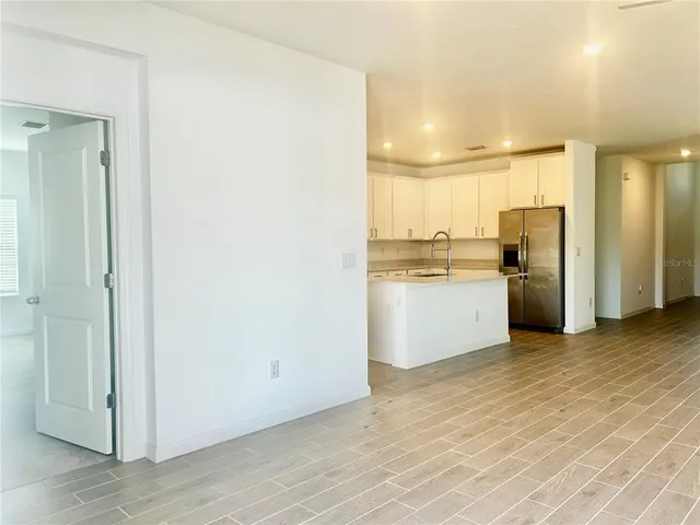 a view of a kitchen with a sink and dishwasher a refrigerator with wooden floor