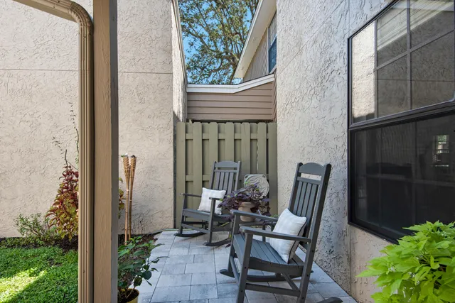 a view of a balcony with chair and potted plants