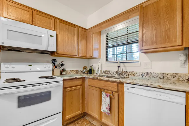 a kitchen with granite countertop cabinets stainless steel appliances a sink and a window