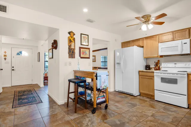 a kitchen with a refrigerator and white cabinets