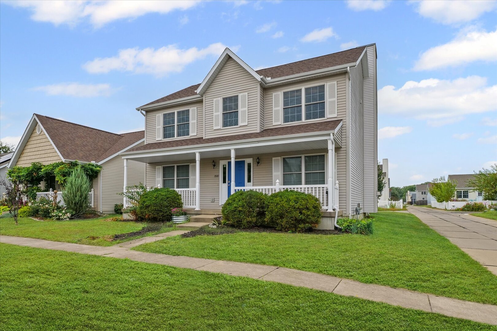 a front view of a house with a yard and plants