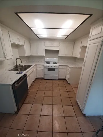 a kitchen with a sink a stove and cabinets