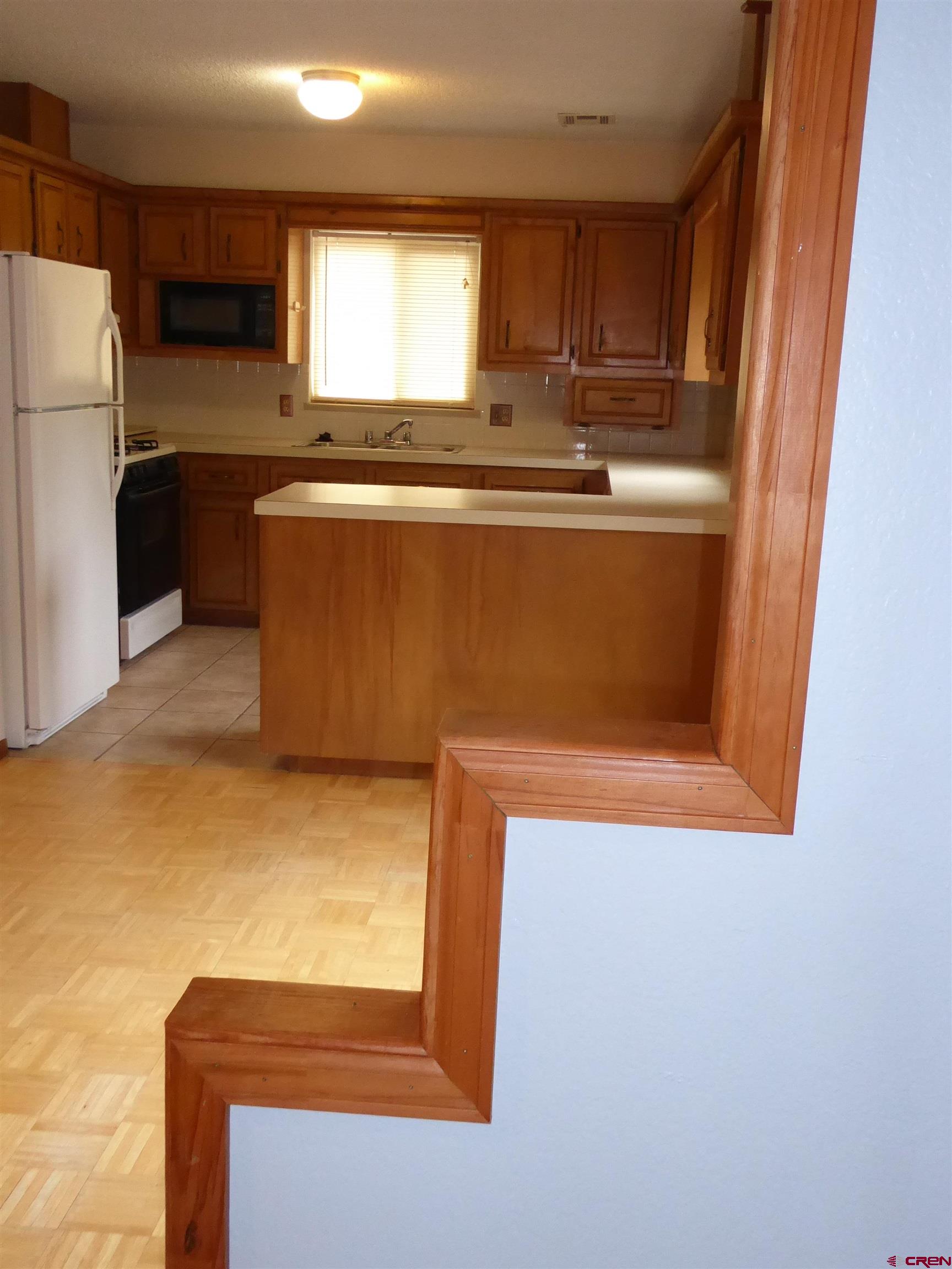 180 Northwest 7th Street Cedaredge, CO 81413 - Photo 23 of 44 a kitchen with stainless steel appliances granite countertop a sink and a refrigerator
