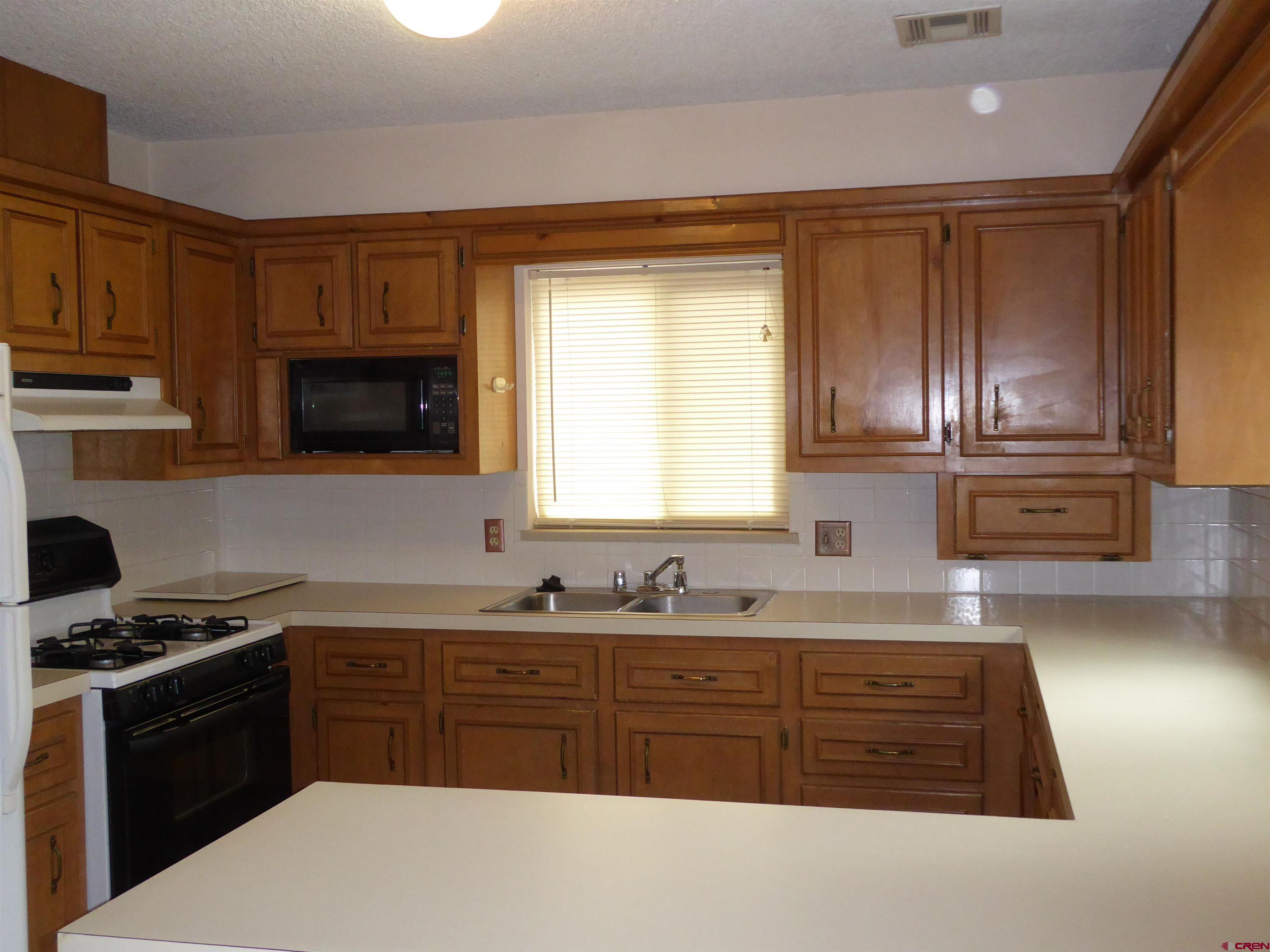 180 Northwest 7th Street Cedaredge, CO 81413 - Photo 26 of 44 a kitchen with granite countertop stainless steel appliances a stove a sink a microwave and cabinets