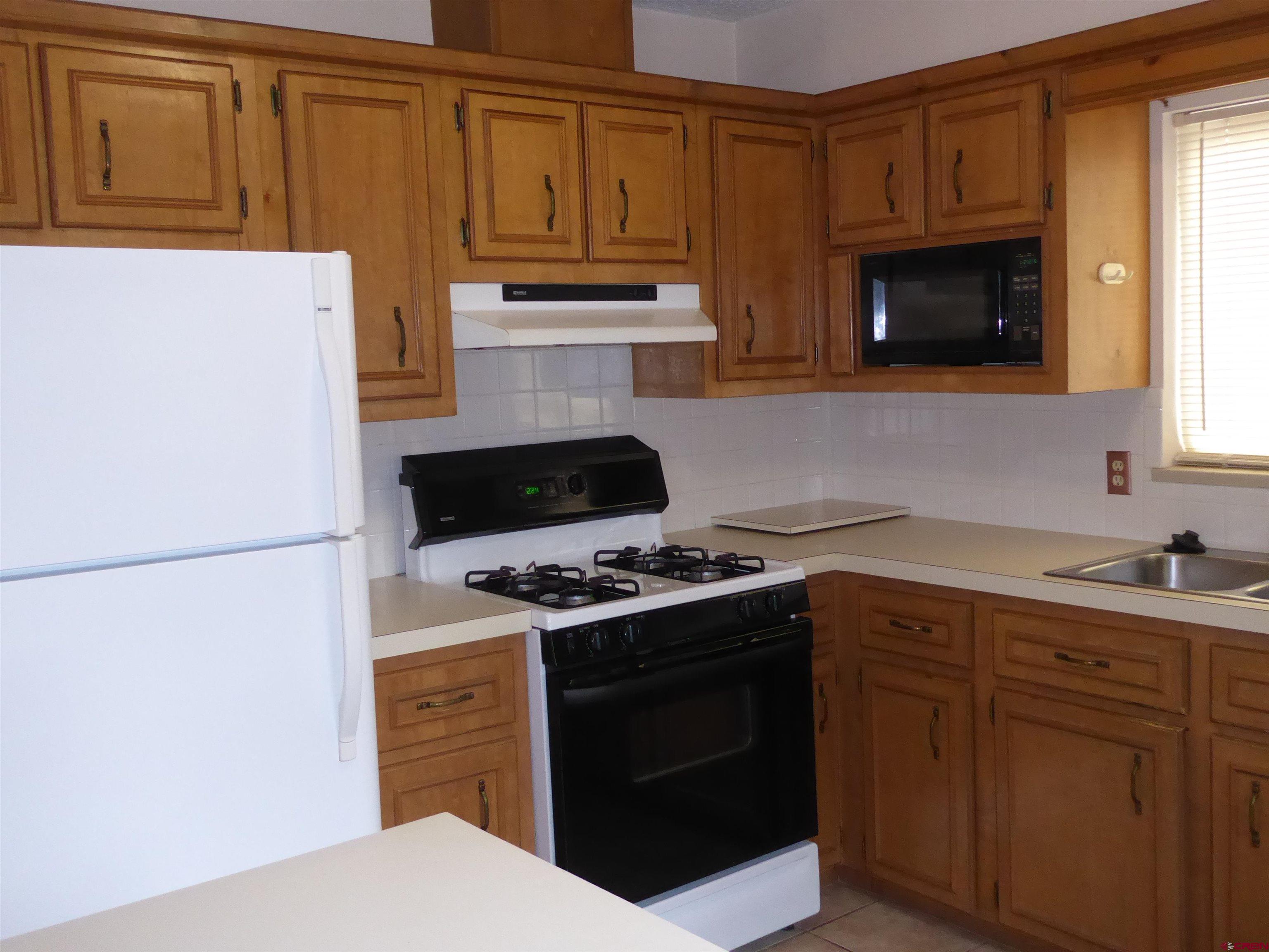 180 Northwest 7th Street Cedaredge, CO 81413 - Photo 27 of 44 a kitchen with stainless steel appliances granite countertop a stove microwave and refrigerator