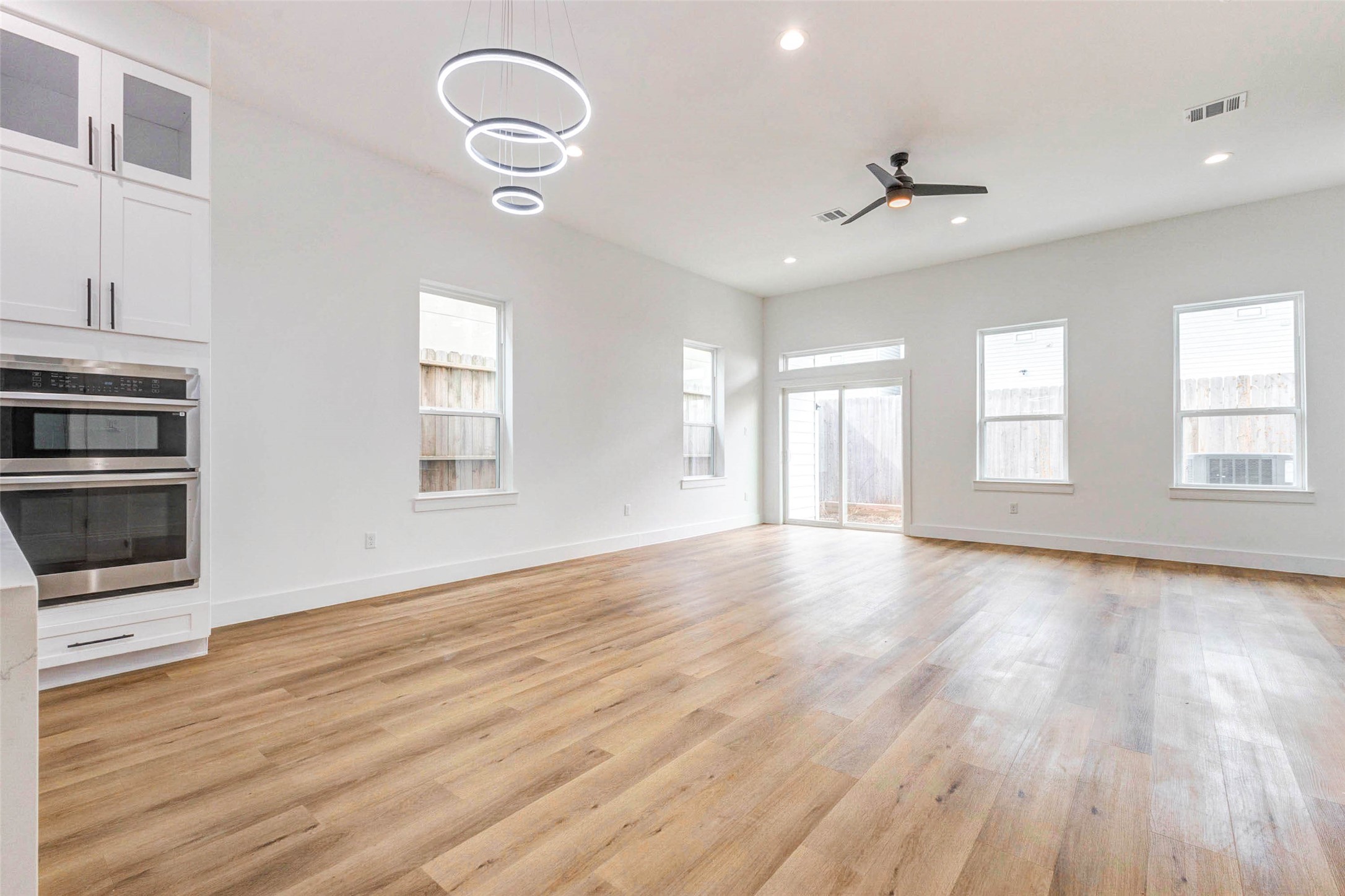2118 Live Oak Street, Unit B Houston, TX 77003 - Photo 12 of 50 An open dining and living area with high ceilings, modern lighting, and great natural light throughout. Warm wood floors and clean finishes give the space an easy, comfortable flow for everyday use or hosting.