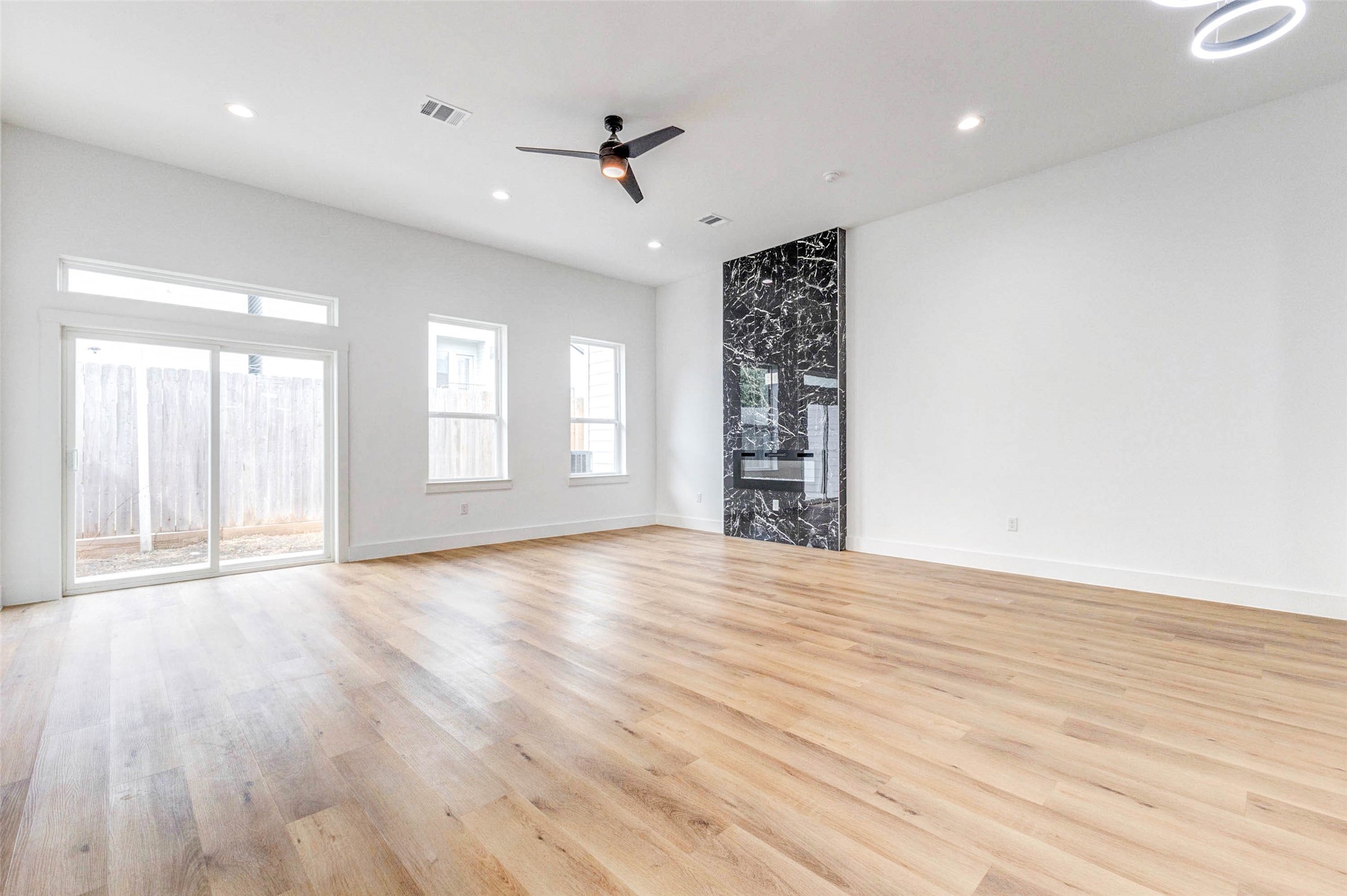 2118 Live Oak Street, Unit B Houston, TX 77003 - Photo 14 of 50 A light-filled living area with warm flooring, tall ceilings, and a clean, open layout. The modern fireplace adds a subtle focal point while keeping the space feeling relaxed and easy to enjoy.