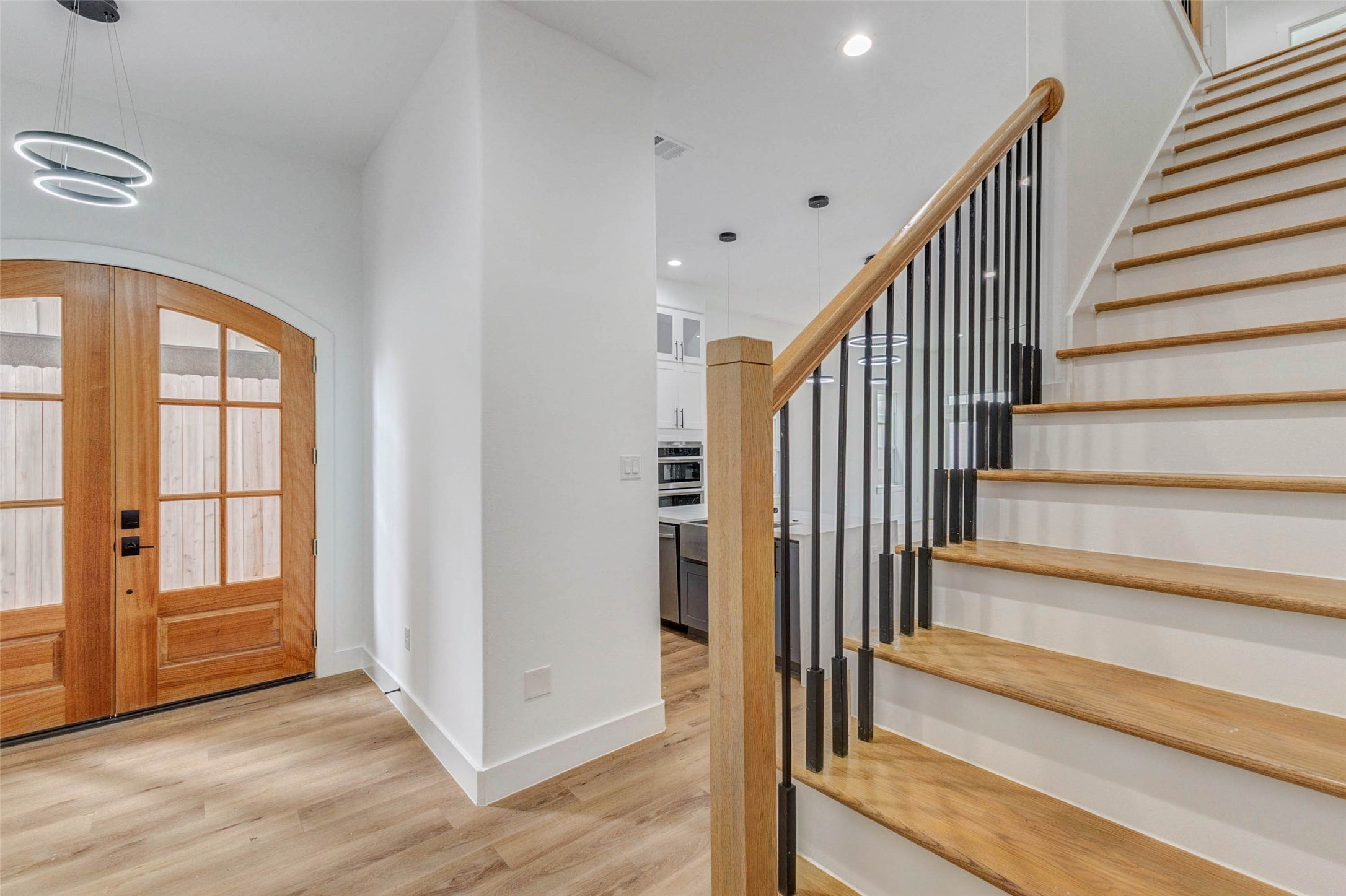2118 Live Oak Street, Unit B Houston, TX 77003 - Photo 20 of 50 A striking entry sets the tone with a sleek, open staircase and refined architectural details throughout. The space feels airy and intentional, offering a polished first impression with a touch of understated luxury.