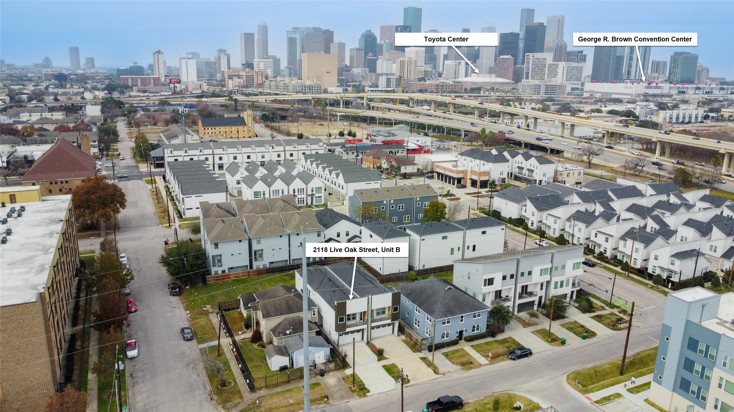 2118 Live Oak Street, Unit B Houston, TX 77003 - Photo 2 of 50 An elevated perspective highlights the home’s placement within a growing pocket of modern residences, framed by clean streetscapes and nearby urban infrastructure. Markers show convenient proximity to Downtown Houston landmarks including Toyota Center and the George R. Brown Convention Center.
