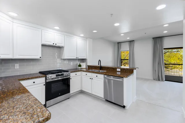 a large kitchen with stainless steel appliances granite countertop a stove a sink and a microwave