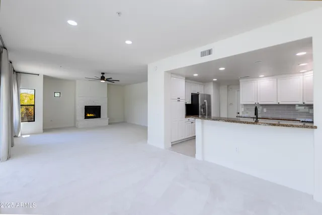 a view of a kitchen with a refrigerator and a living room
