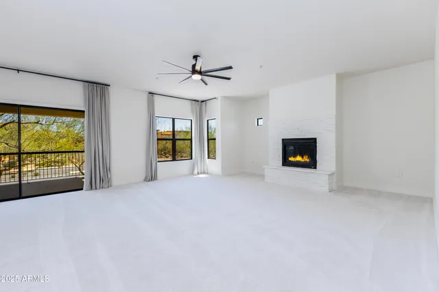 a view of empty room with a fireplace and window
