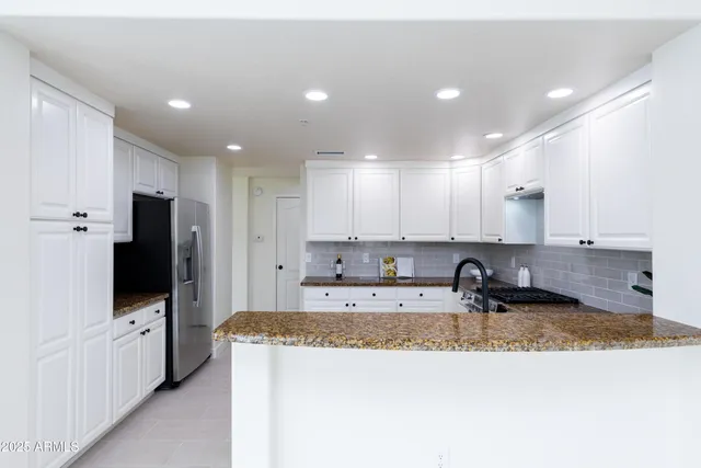 a kitchen with kitchen island sink refrigerator and stove