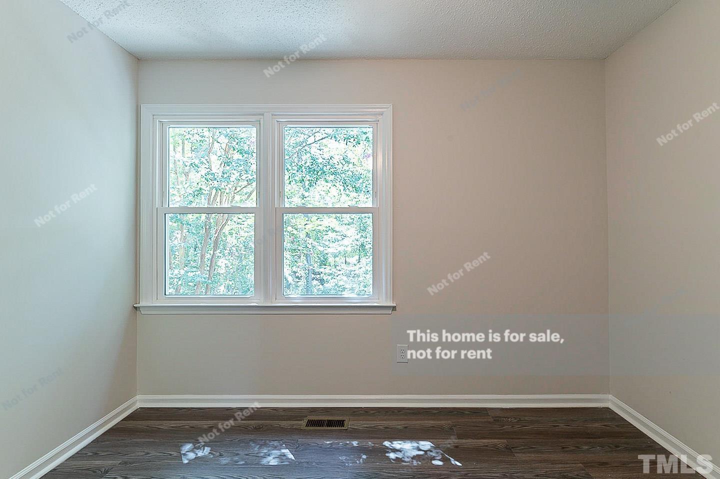 565 Darby Glen Lane Durham, NC 27713 - Photo 15 of 18 a view of an empty room with wooden floor and a window