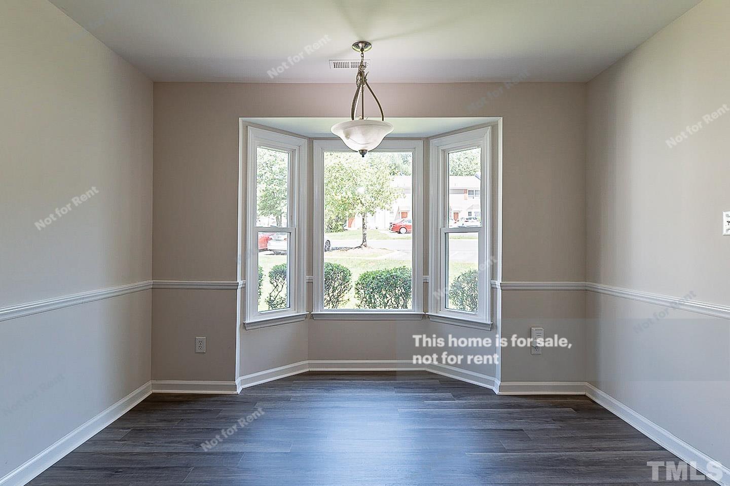 565 Darby Glen Lane Durham, NC 27713 - Photo 8 of 18 a view of an empty room with wooden floor and a window