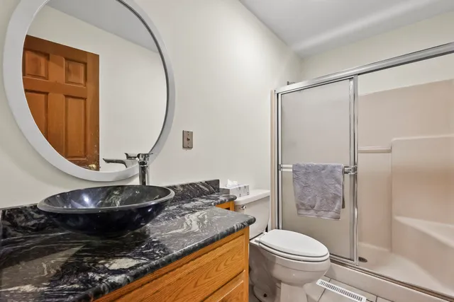 a bathroom with a granite countertop sink toilet and a mirror