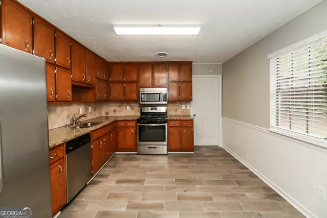 a kitchen with stainless steel appliances granite countertop a refrigerator and a stove