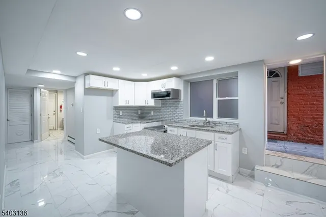 a kitchen with stainless steel appliances granite countertop a sink and a refrigerator