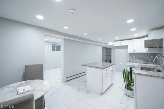 a kitchen with granite countertop a sink a stove a refrigerator and a stove