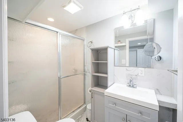 a bathroom with a sink a toilet and shower