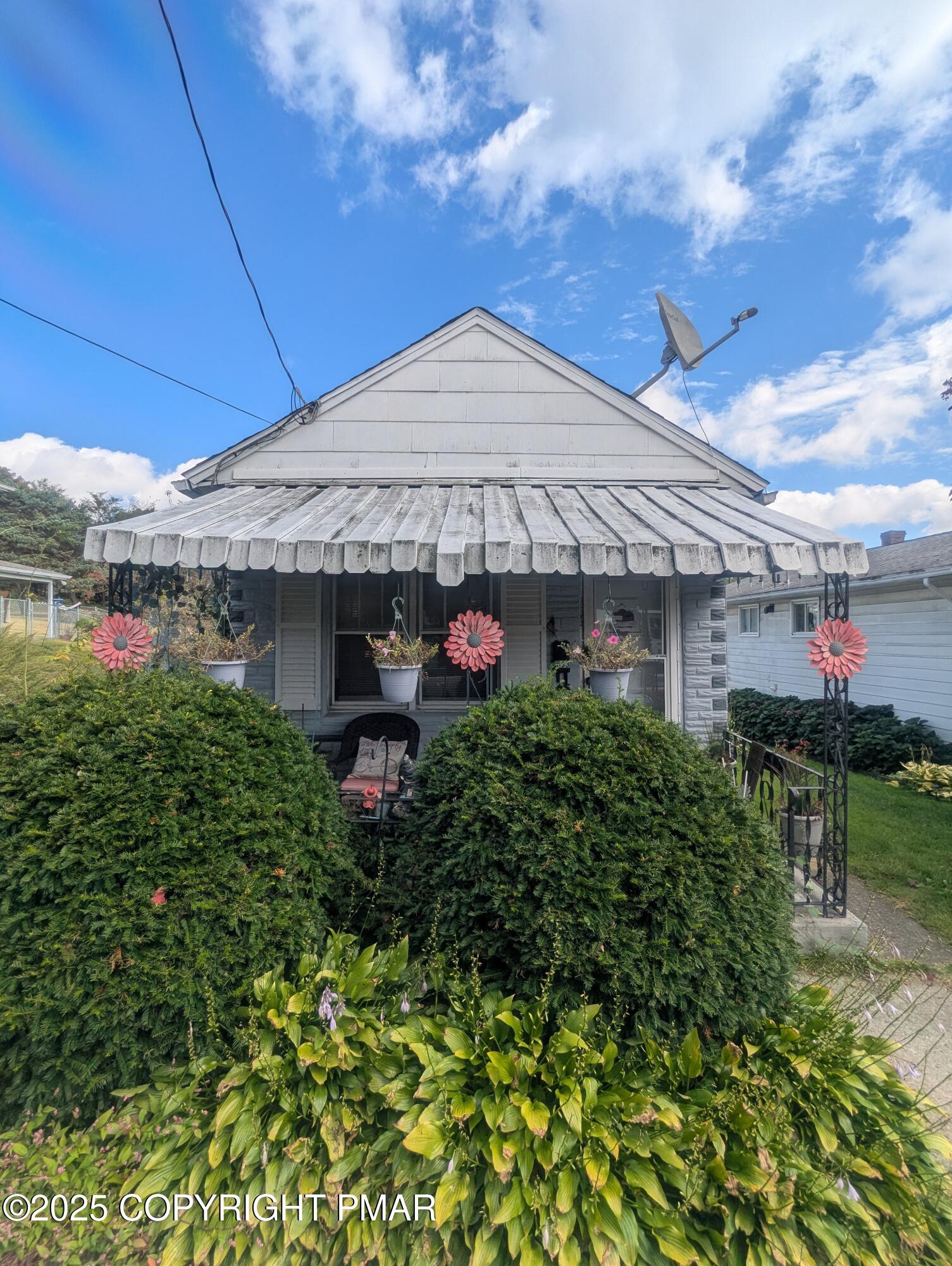 a front view of a house with plants