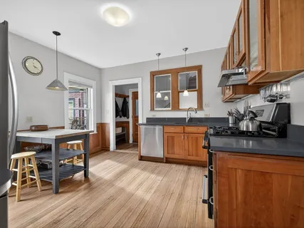 a kitchen with stainless steel appliances granite countertop wooden floors sink and cabinets
