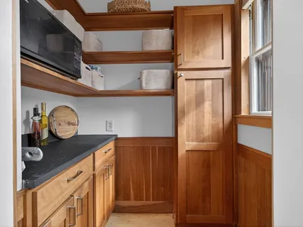 a utility room with stainless steel appliances wooden floor and a window