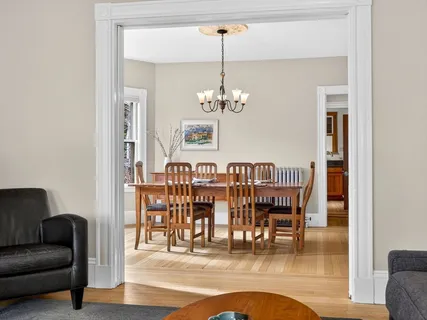 a dining room with furniture a chandelier and wooden floor