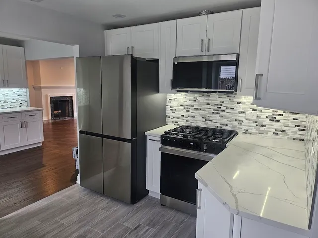 a kitchen with granite countertop a stove and a refrigerator