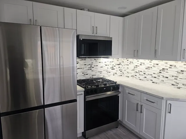 a kitchen with granite countertop a sink stove and refrigerator