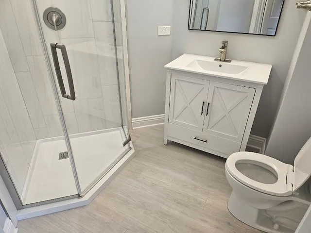 a white toilet sitting next to a bathroom sink