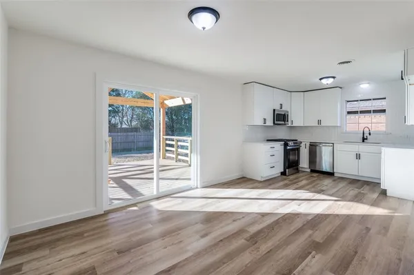 a view of a kitchen with wooden floor and windows