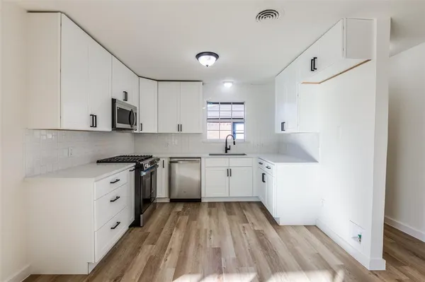 a kitchen with granite countertop a sink stove and cabinets